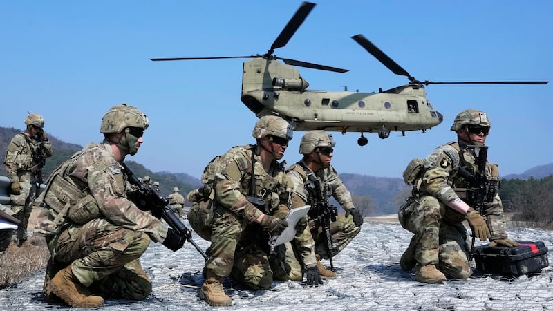 FILE - U.S. Army soldiers wait to board their CH-47 Chinook helicopter during a joint military...