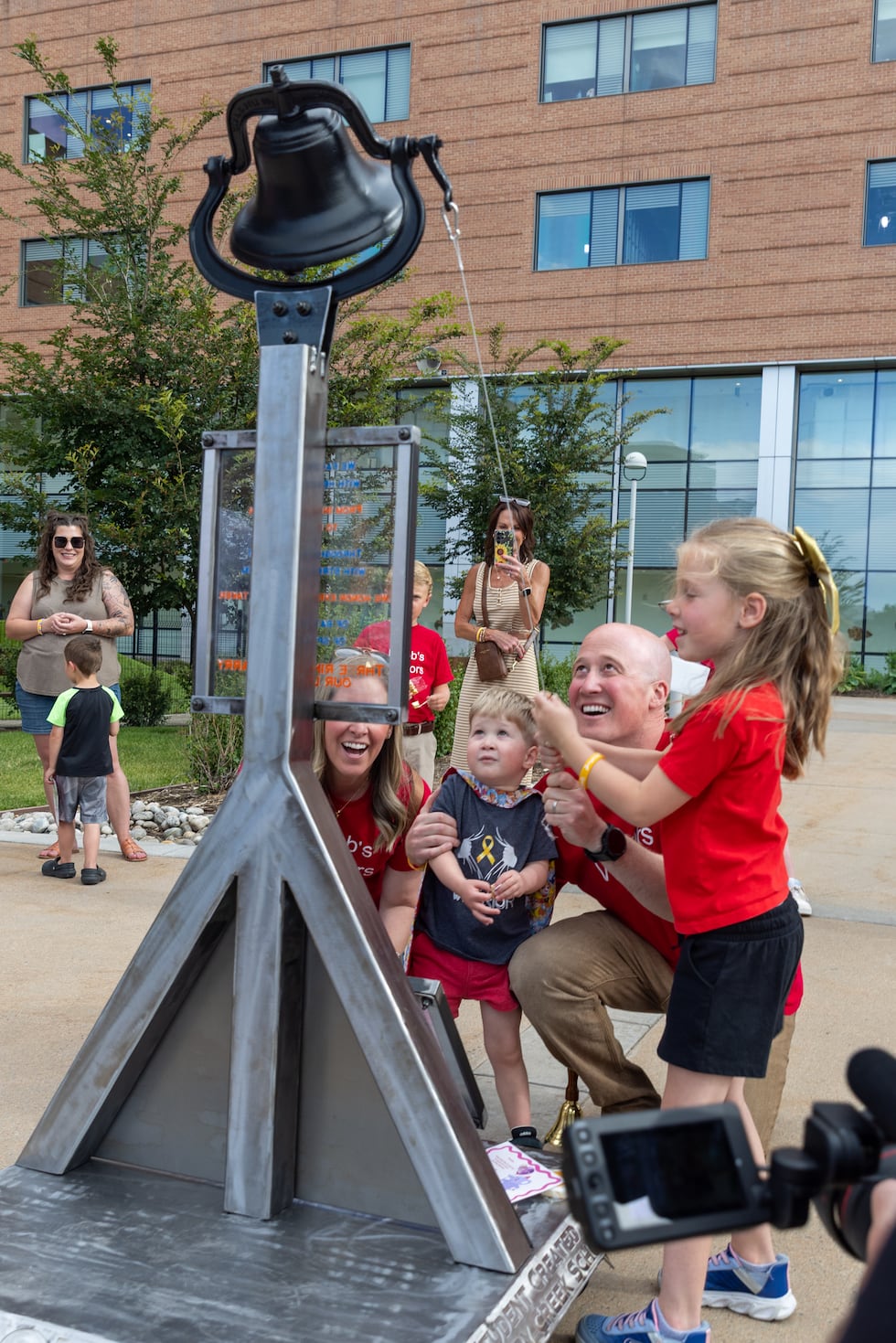 Jacob ringing the warrior bell alongside family.