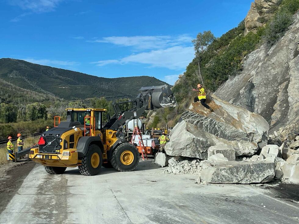 The size of the boulder -- here in smaller chunks -- can be seen compared to the road workers.